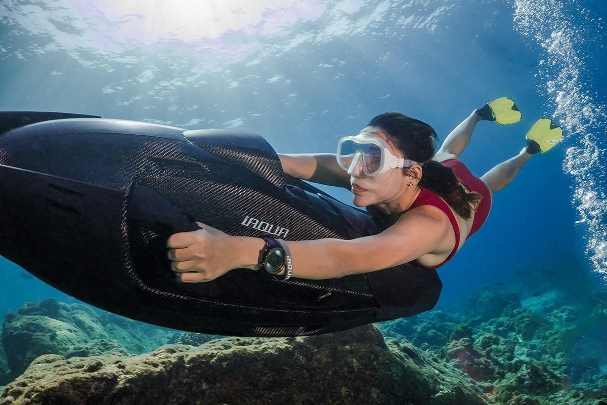 Girl free diving underwater with iAQUA AquaDart World's most powerful sea scooter